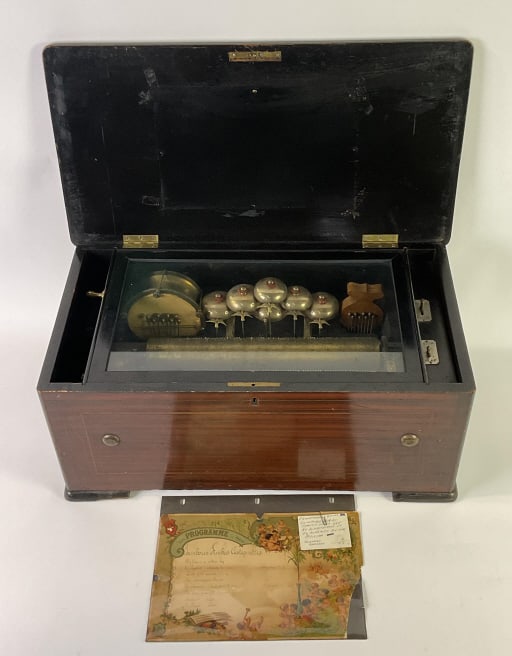 Rare Swiss 6-Bell Orchestral Music Box 19th C.: With percussion and castagnettes, 19th century. Plays 8 songs including The Star Spangled Banner and The Mulligan Braves. 19th century. It measures 10 inches tall x 23 inches x 12 inches deep.