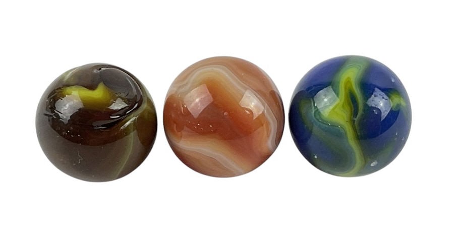 (3) Glass Glowing Shooter Marbles: (3) Glass Glowing Shooter Marbles each featuring with unique swirls in colors such as green, yellow, red, brown, white. Each marble is about 1 in. in size.