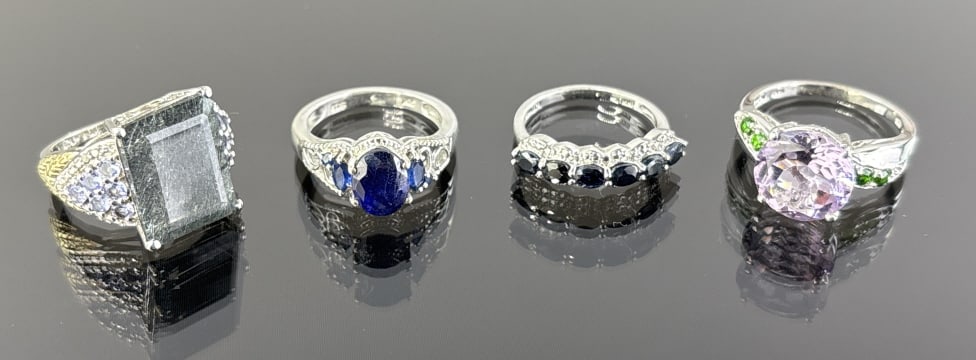 (4) 925 Sterling Silver rings featuring Different Colored Gemstones. Total Weight: 19.28 grams.: (4) 925 sterling silver rings featuring different colored gemstones. Rings are size 9 and 7. The first ring features a gray rectangle-cut stone accented with light purple gemstones. The second ring fe