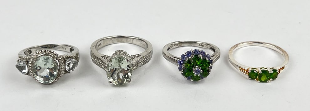 (4) 925 Sterling Silver Rings featuring Green Gemstones. Total Weight: 13.22 grams: (4) 925 sterling silver rings featuring green gemstones. Sizes 7 and 9. The first ring features an oval-cut light green gemstone. The second ring features an oval-cut light green gemstone with clear g