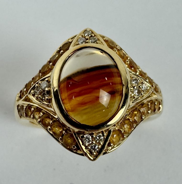 14K Gold Ring featuring a Reddish-orange Gemstone: TW: 6.38 grams. 14K Gold Ring featuring a reddish-orange gemstone with yellow gemstone accents. Size 7