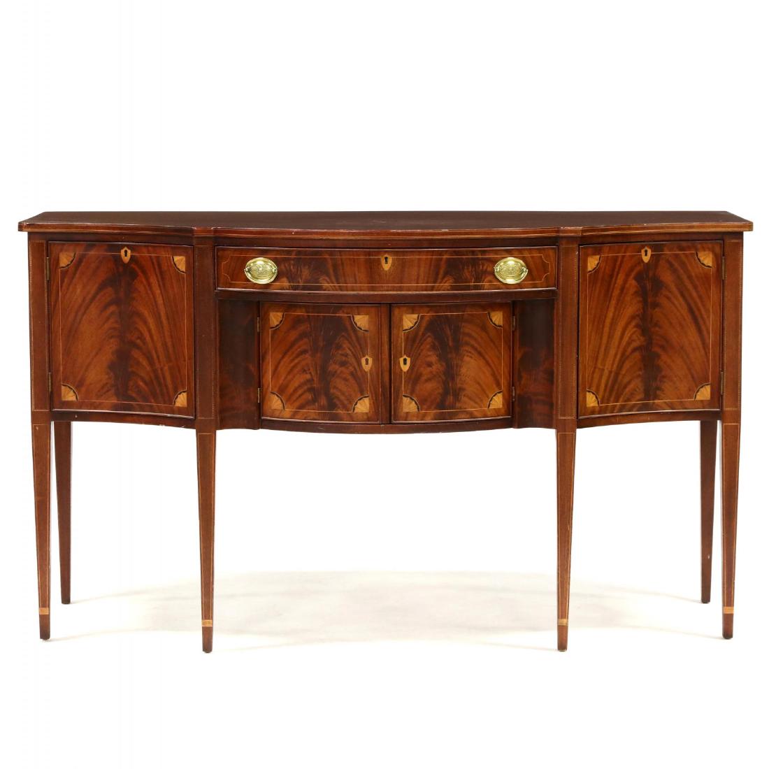 Potthast Brothers, Federal Style Inlaid Sideboard: early 20th century, mahogany, with flame mahogany veneers, serpentine form, one drawer, four cabinet doors, all having line inlay with corner fan, raised on square tapered legs, with barber pole and l