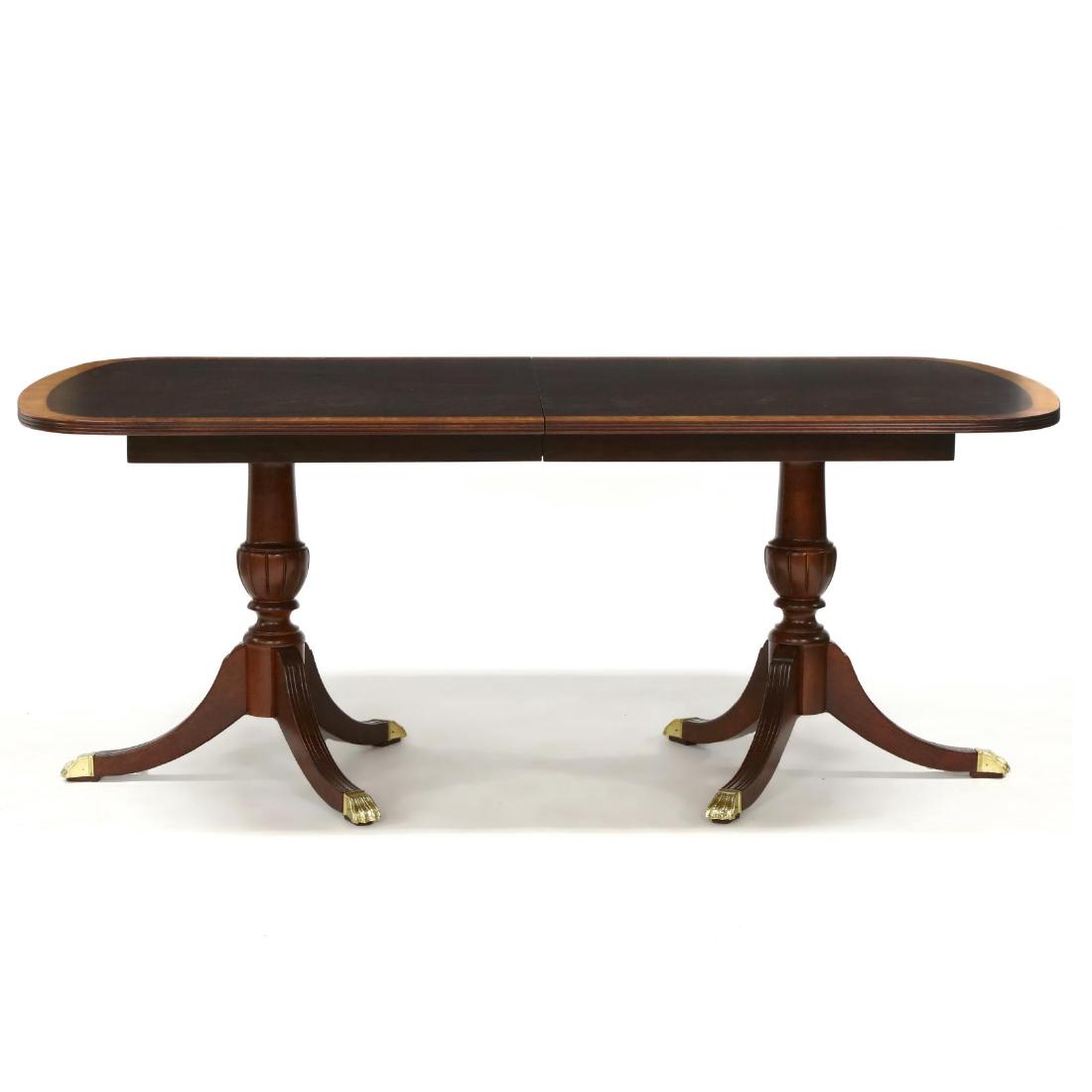Federal Style Inlaid Dining Table: late 20th century, mahogany, rectangular top with banded and inlaid border, reeded edge, double urn form pedestal, downswept legs with brass paw feet, with two leaves, marked "Masterpiece". 31 x 46 x