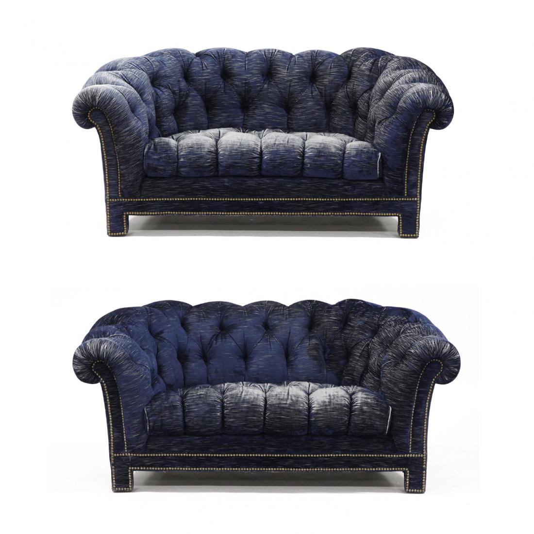 Pair of Designer Chesterfield Settees: late 20th century, navy distressed velvet upholstery, with brass nailhead trim, raised on short straight legs. 26 x 64 x 36 in. Collection of Barry & Bonnie Setzer of Blowing Rock, NC Additional high-