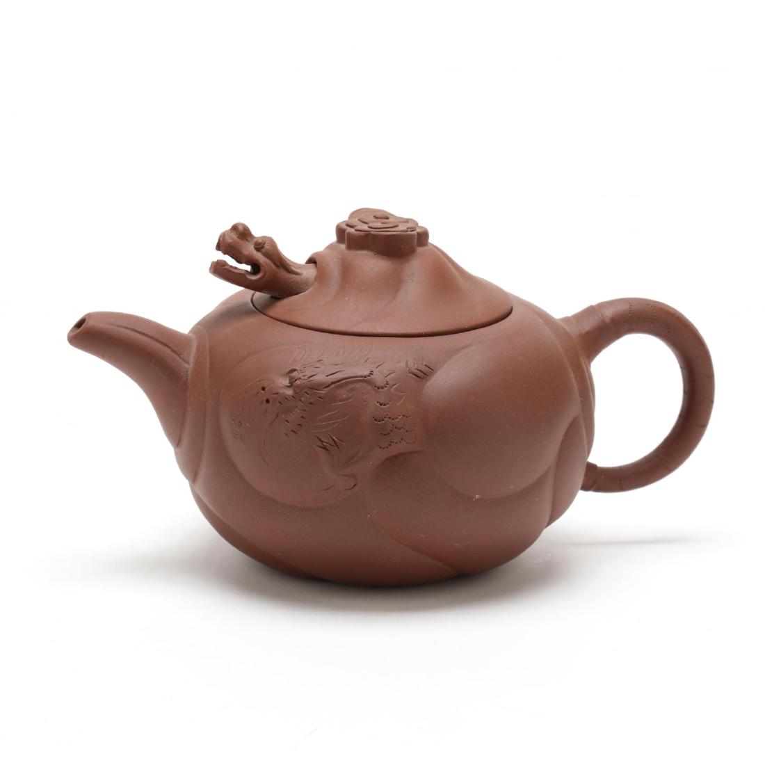 Chinese Yixing Pottery Teapot: 20th century, red clay with moveable dragon lid, and relief decorated pot, unmarked. 4 in. tall. When tea is poured with the lid on, the dragon pops his head and tongue out towards the cup. Private Co
