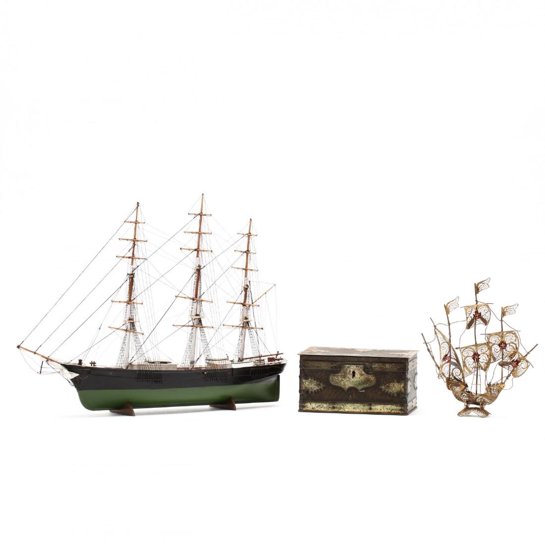 Two Vintage Ship Models and a Treasure Chest Tin: to include a contemporary model wooden ship and a vintage Portuguese silver-gilt gallon model ship; also to include a Geo. Bassett & Co. Ltd. Confectioners treasure chest style tin, signed. Tallest 13