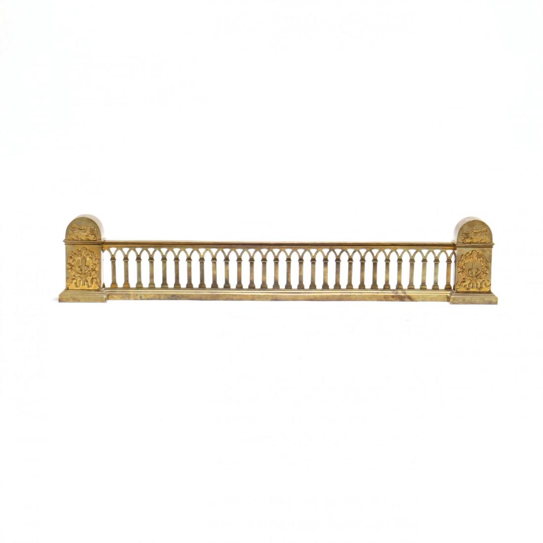Neoclassical Reticulated Brass Chenet: 19th century, tombstone ends with applied lion and wreath decoration on a Gothic arched reticulated suspension bar. 8 x 43 x 3 in. From the Collection of Tony & Linda Bakker, Charleston, SC Additional