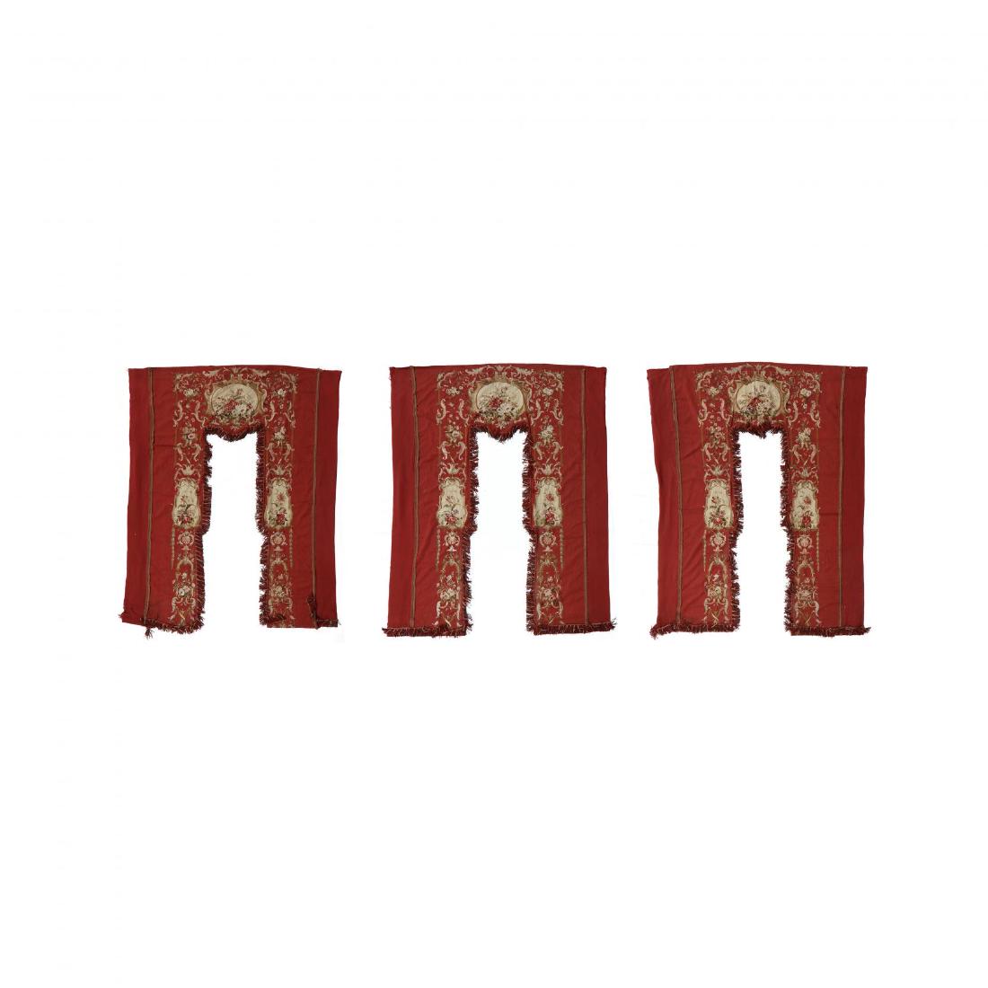 Suite of Napoleon III Aubusson Window Surrounds: late 19th century, the portieres with crimson ground, finely woven with floral and vine design elements, with multicolor fringe and applied braid. Two HOA 8 ft. 10 in. x 10 ft. 11 in.; Each panel 3 ft