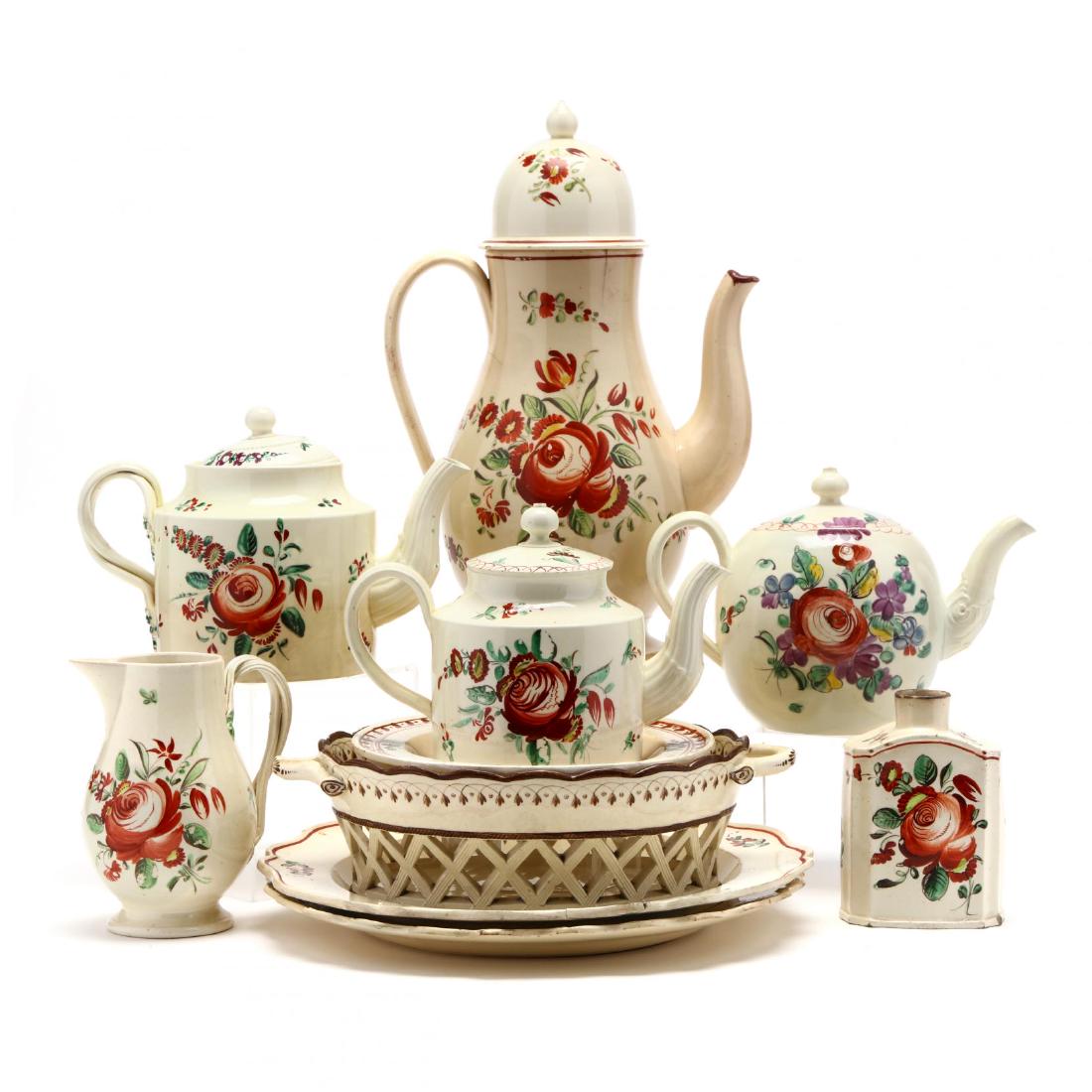 Group of Antique Creamware Table Accessories: late 18th or early 19th century, cream field with floral painted decorations, to include a teapot with high dome lid, a tea caddy, three small tea pots, a creamer, a sweetmeat basket, and three plates