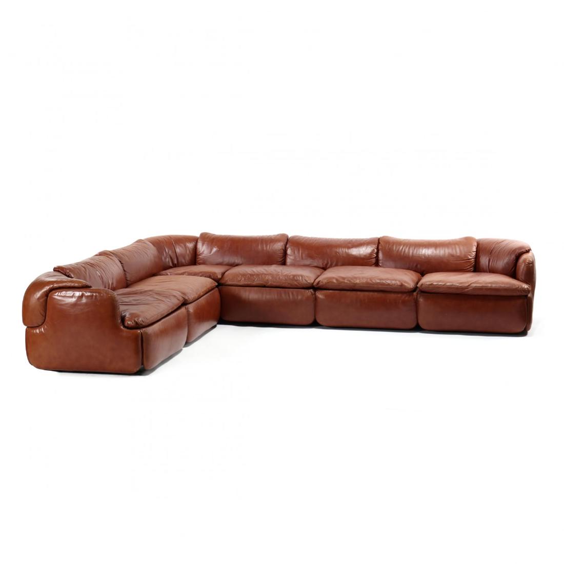 Alberto Rosselli (Italian, 1921-1976), Confidential: Saporiti Italia, circa 1990, rich brown leather, two part sectional with loose cushions, on a recessed back, plastic base, marked. Each section 20 x 90 x 32 in. From the Estate of the late Nicholas an