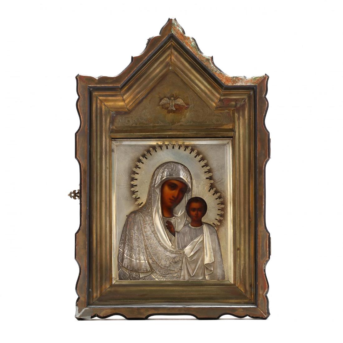 An Antique Russian Icon of the Virgin of Kazan: the silver oklad with 1908-1926 Kokoshnik mark for Moscow and Cyrillic maker's mark, hand-painted depiction of the Madonna and Christ Child, presented under glass in a shadow box frame with brass line