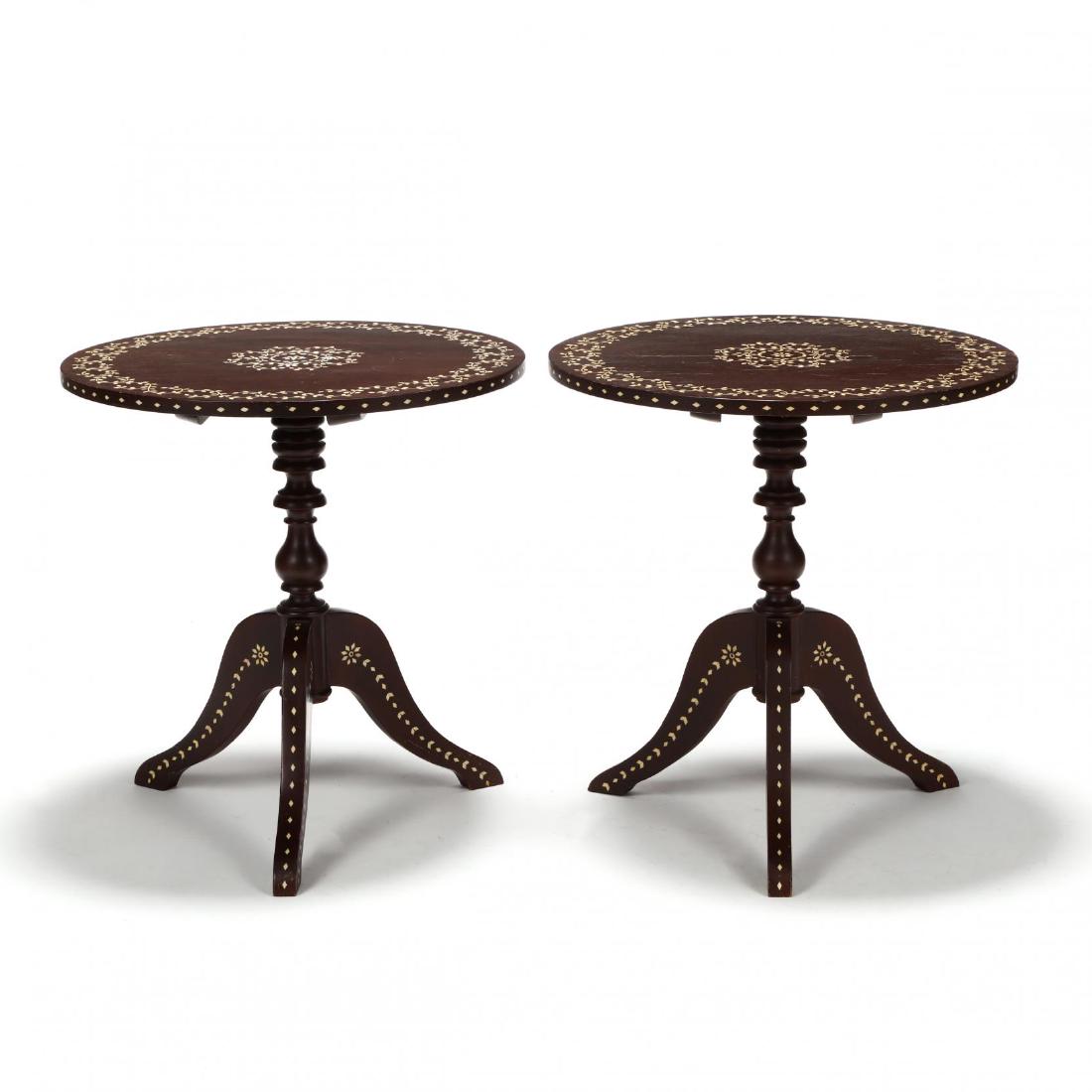 Pair of Anglo Indian Inlaid Tilt Top Tea Tables: second half 20th century, dark stained mahogany, circular top with flowering vine decoration, turned standard on down-swept legs. 24 x 23 in. diameter. Additional high-resolution photos are available