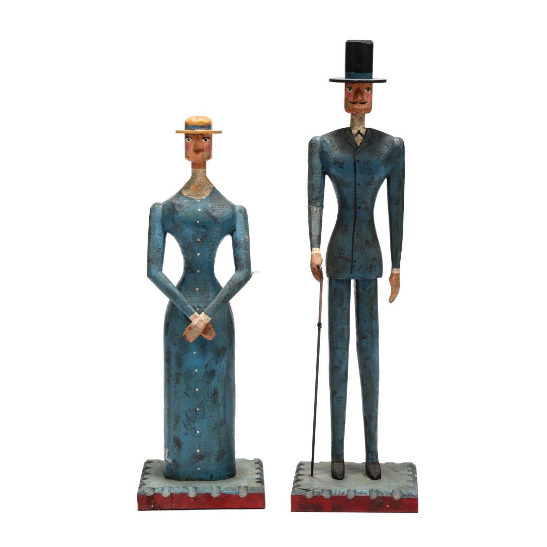 Curtis Jere, Folky Carved and Painted Wood Couple: 1980s, in the form of a well dressed man and woman on chip carved plinths, signed. Taller 34 in. Collection of John and Cathy Albright, Southern Pines, NC Additional high-resolution photos are availab