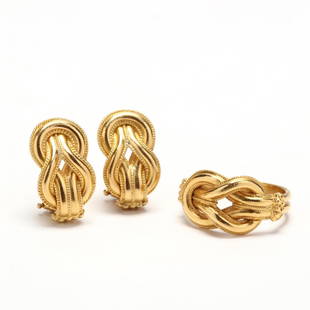 18KT Gold Knot Suite, Ilias Lalaounis: the ring featuring an interlocking knot motif with milgrain and beaded detailing with a ridged shank; earrings en suite and completed with posts and Omega backs. Both with maker's mark for Ilias Lalao