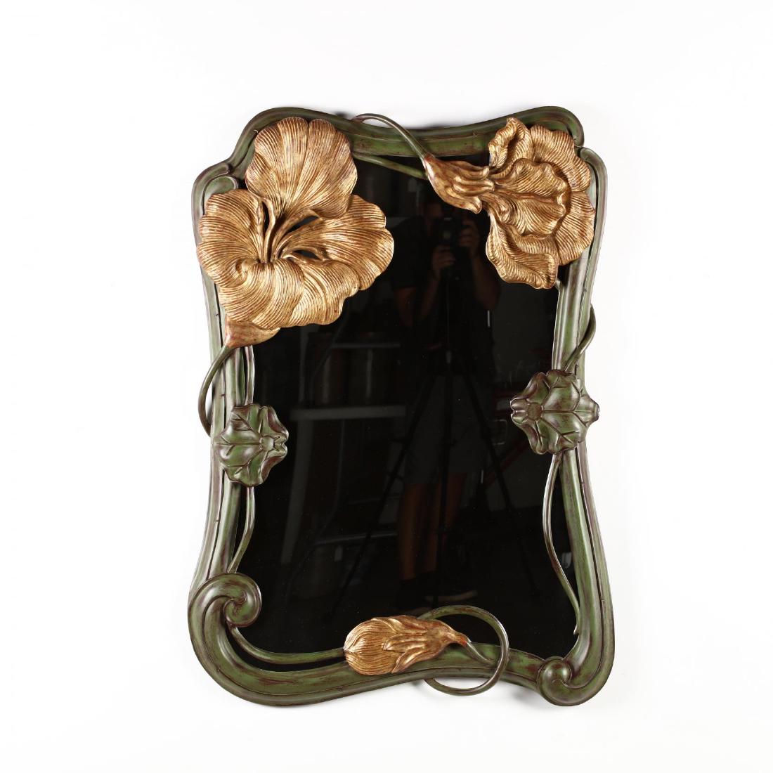 An Art Nouveau Style Painted and Gilded Wall Mirror: An Art Nouveau Style Painted and Gilded Wall Mirrorfirst half of the 20th century, with lily pad motif to shaped frame. 46 x 32 in. From the Collection of Lane Montgomery, New York, NY. From Mrs. Mont