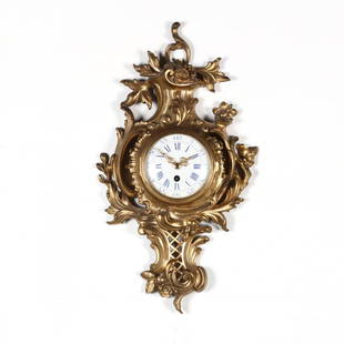 French Rococo Style Wall Clock: French Rococo Style Wall Clockearly 20th century, enamel face with Roman numerals, gilt metal case. 20 x 11 in. Additional high-resolution photos are available at LelandLittle.com