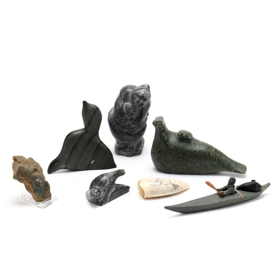 Grouping of Inuit Carvings: Grouping of Inuit Carvings mid 20th century, including six carved stone figures with signatures and Canadian art paper labels and one carved whale's tooth scrimshaw signed M M Cohen, 73. Tallest 6 in.