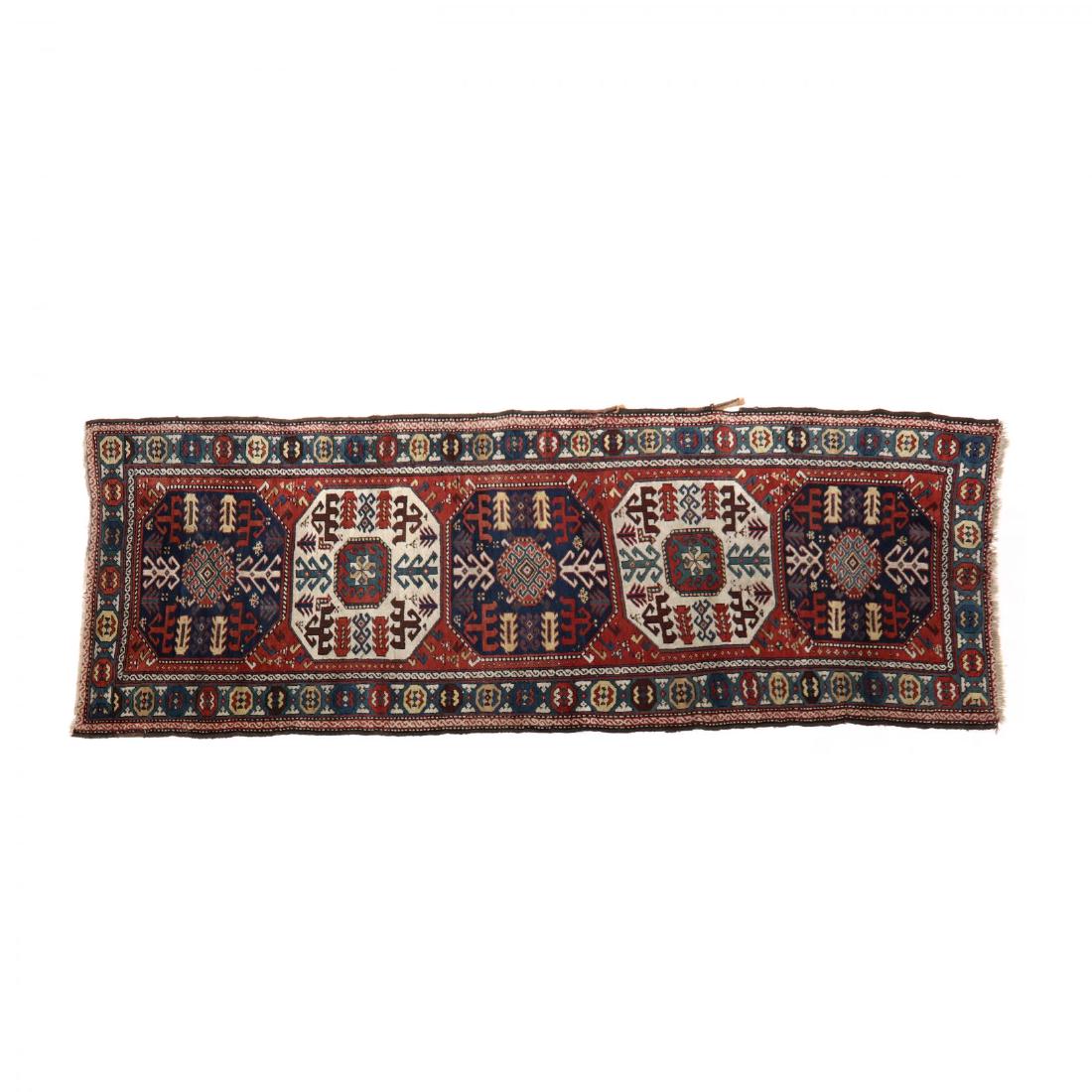 Caucasian Kazak Area Rug: Caucasian Kazak Area Rugred field with five octagonal shaped medallions, with blue main guard border. 3 ft. 9 in. x 10 ft. 7 in. Estate of the late John M. Bahner, Jr., Albemarle, NC Additional high-