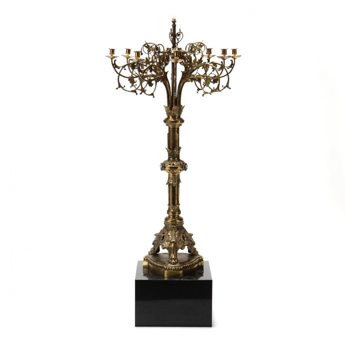 An Antique Brass Floor Candelabrum: An Antique Brass Floor Candelabrum likely French, late 19th century, eight light form with scrolling foliate arms, foliate crown motif to standard, the central standard featuring three rosettes with c