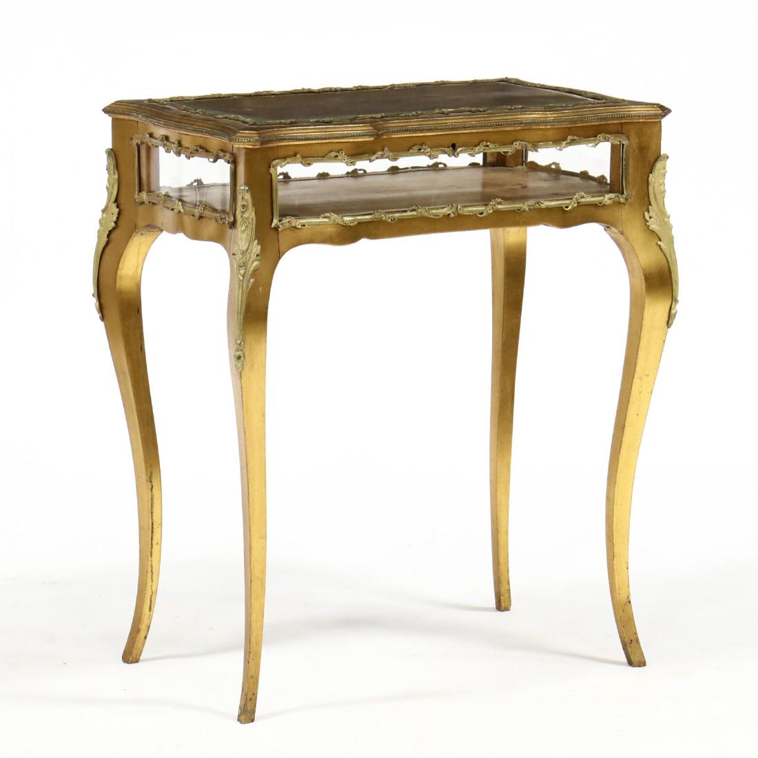 Louis XV Style Gilt Vitrine Table: Louis XV Style Gilt Vitrine Table circa 1890, shaped rectangular form, top with hinged beveled glass lid with gilt interior, case with ormolu mounts and raised on tall cabriole legs. 29 x 26 x 16 in. 