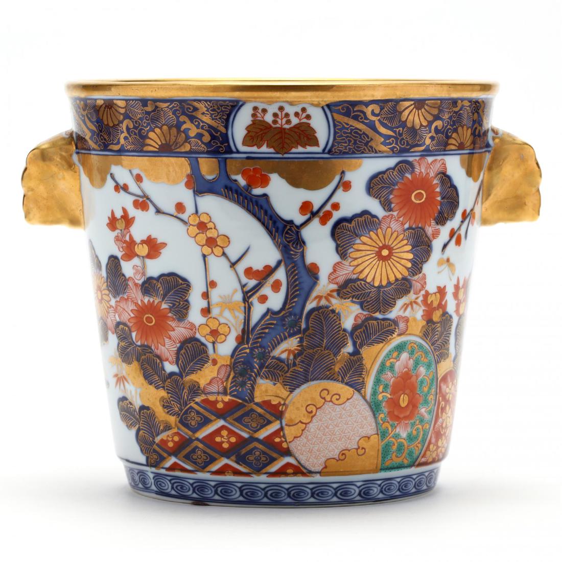 Imarii Style Porcelain Ice Bucket: Imarii Style Porcelain Ice Bucket gilt decorated with Asian interpretation design, lion form gilt handles, unmarked. 7 x 7.5 in. The Estate of the late Rushton W. Hays, St. Augustine, FL Additional hi