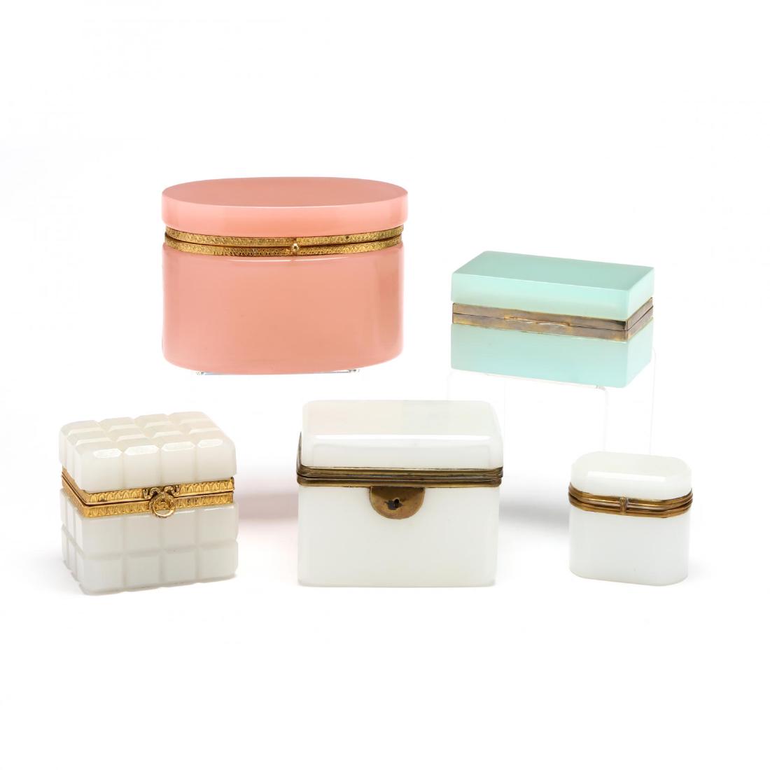 Five French Opaline Glass Dresser Jewelry Caskets: Five French Opaline Glass Dresser Jewelry Casketscirca 1900, a rare pink oval form (4 x 6 in.); a cut glass 'quilted' square box with fine gilt brass mountings (3.5 x 3.5 in.); a celadon glass box (ru