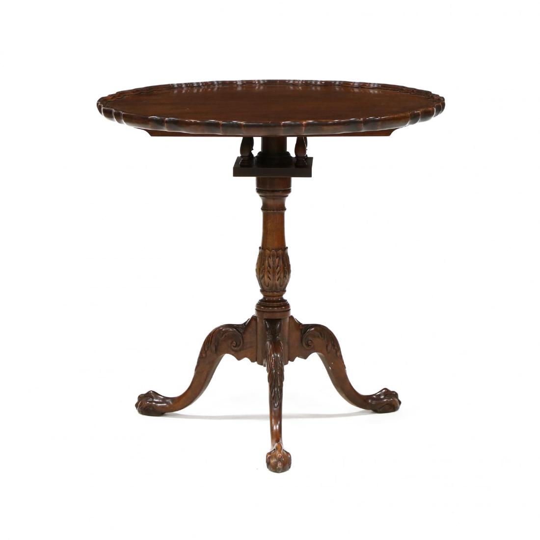 Baker, Chippendale Style Carved Mahogany Pie Crust Tilt: Baker, Chippendale Style Carved Mahogany Pie Crust Tilt Top Tea Tablelate 20th century, top with applied molded edge, birdcage, acanthus carved standard and knee, on ball and claw feet, labeled. 29.5