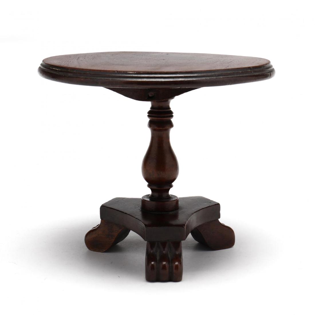 An English Regency Miniature Tilt Top Tea Table: An English Regency Miniature Tilt Top Tea Table mid 19th century, mahogany, single board circular top with molded edge, baluster turned standard on a tripod base with scrolled feet. 7 x 8.5 x 8.25 in.