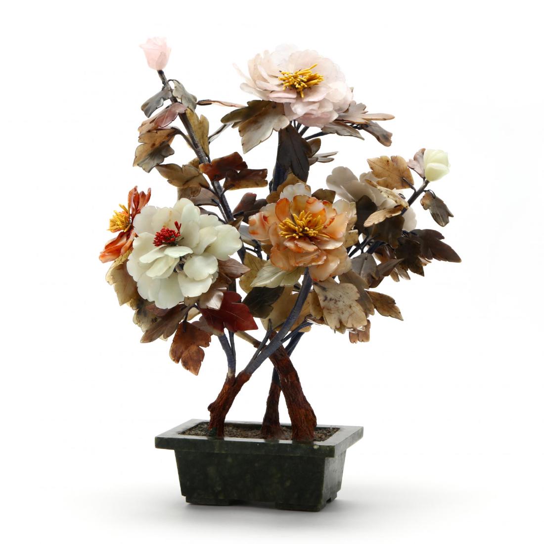 A Chinese Hardstone Tree with Flowers: A Chinese Hardstone Tree with Flowers early 20th century, the flowers comprised of pink, amber, and pale celadon petals, the leaves of carved mottled hardstone, the three naturalistic trunks affixed w