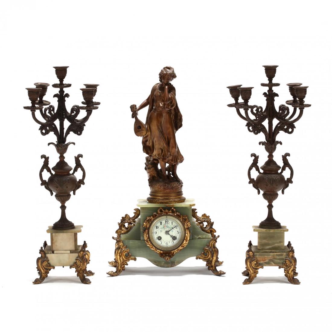 Antique French Alabaster Figural Clock Garniture Set: Antique French Alabaster Figural Clock Garniture Setcirca 1900, gilt spelter and green alabaster, the clock with painted enamel face featuring a figure titled "Mignon" after Luca Madrassi, together wi
