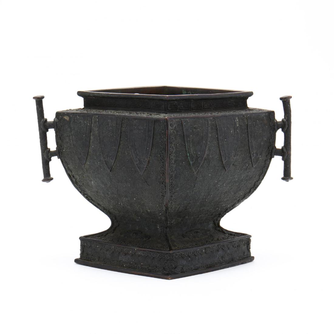 A Chinese Bronze Censer: A Chinese Bronze Censer 19th century, offset square form with overall raised decoration of lappet leaves, two handles, appears unmarked. 7 x 11 x 7.5 in. From the Estate of the Late Eleanor Kennedy, R