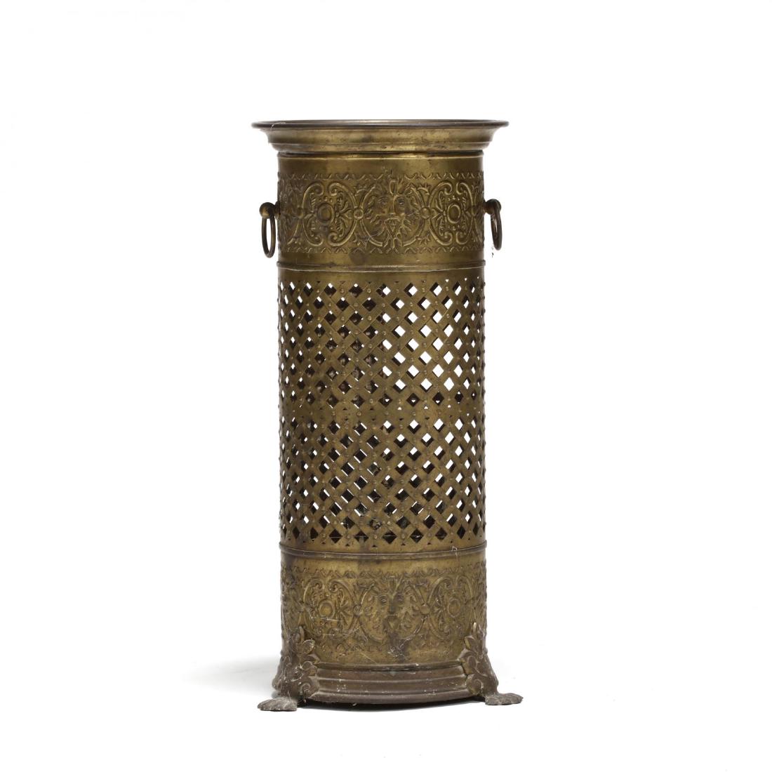 Vintage Brass Umbrella Stand: Vintage Brass Umbrella Standmid 20th century, repousse mask and foliate decoration with ring handles, reticulated panel on paw feet. 22 x 10 in. diameter. From the Estate of the late Mary Duke Biddle