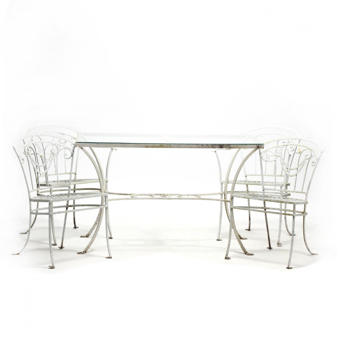 Five Piece Vintage Iron Patio Set: Five Piece Vintage Iron Patio Setmid 20th century, later white paint, including a rectangular table with inset glass top, along with two armchairs and two side chairs, with a stylized swag motif back,