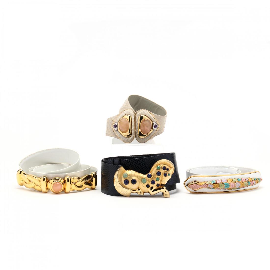 Group of Four Belts,Judith Leiber: Group of Four Belts,Judith Leiberthe first a wide navy snakeskin belt with a large gold tone horse motif buckle decorated with sodalite and green quartz stones (2.25 x 37.5 in., adjustable); the secon
