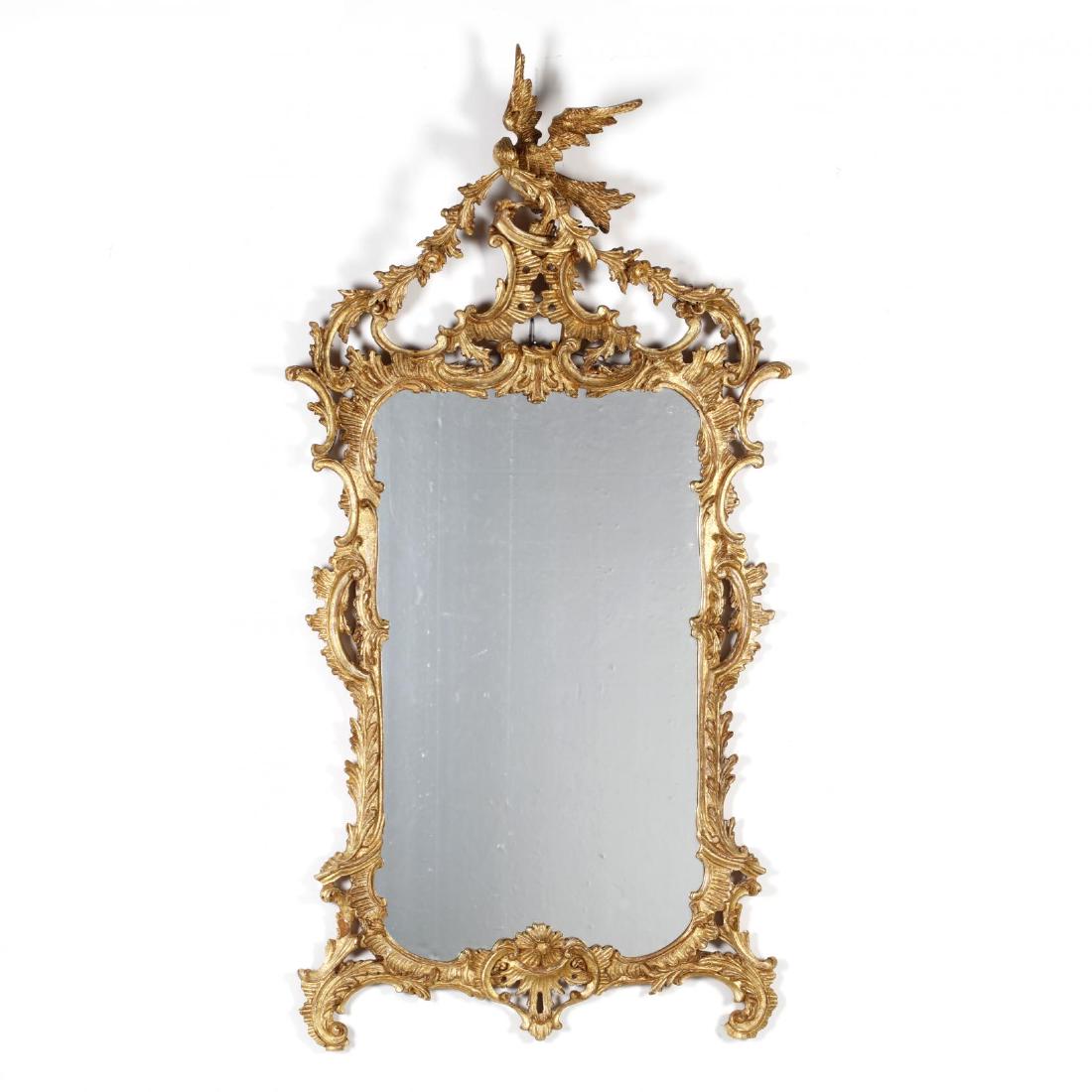 Italian Rococo Style Carved and Gilt Mirror: Italian Rococo Style Carved and Gilt Mirror late 20th century, carved and gilt wood frame with pronounced spread wing hoho bird and floral swag pediment, rectangular mirror with a foliate carved surro
