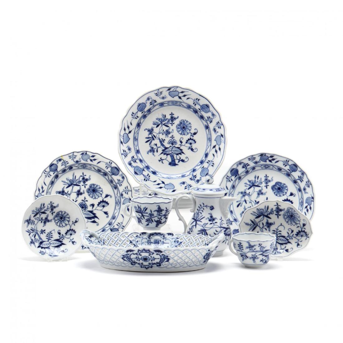 A Group of Meissen "Blue Onion" Table Ware: A Group of Meissen "Blue Onion" Table Ware to include: three plates with pommel mark (one with glue drippings) (8 3/8 in.); a single plate (9.5 in.) and an oval bread tray stamped "Meissen"; two cups;