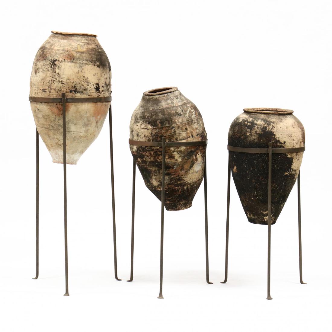 Three Terracotta Amphora Vessels on Stands: Three Terracotta Amphora Vessels on Stands early 20th century, terracotta vessels on later iron stands. Tallest 60 in.