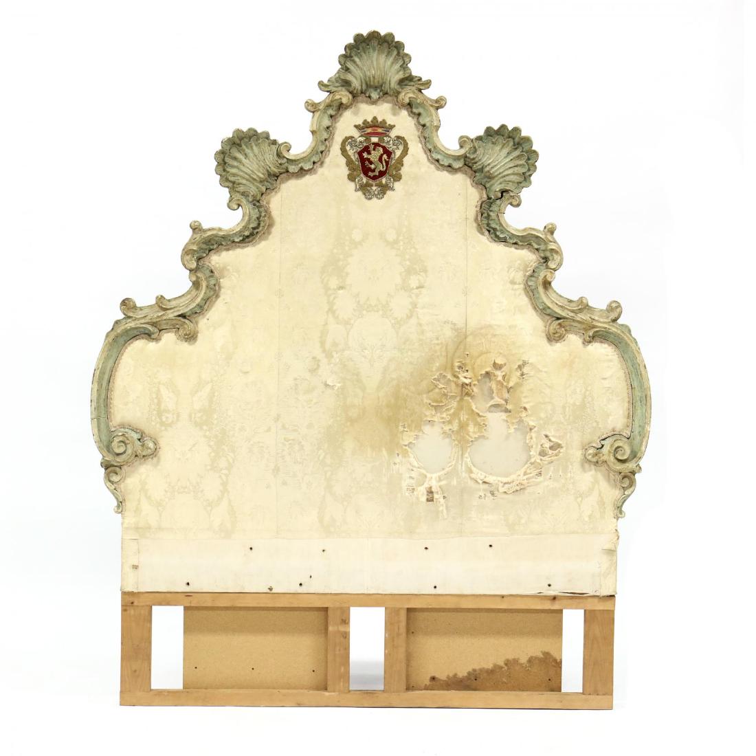 Italian Rococo Carved and Painted Headboard: Italian Rococo Carved and Painted Headboard18th century, tall upholstered headboard featuring a relief shell carved frame, with old paint, headboard with applied crest. DOA 77 x 63 in. Raised on a 13