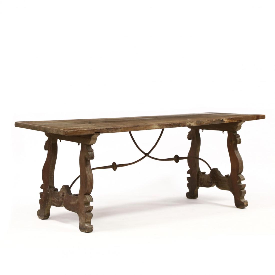 Spanish Baroque Iron - Sprung Library Table: Spanish Baroque Iron - Sprung Library Table17th century, walnut, large single board top, on scrolled legs, acanthus leaf and molded edge, with iron cross bars. 31 x 82 x 29.5 in. From the Collection o