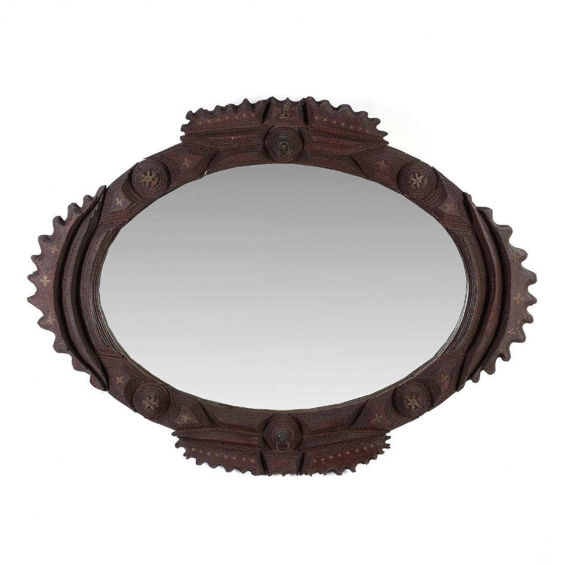 An Oval Tramp Art Wall Mirror: An Oval Tramp Art Wall Mirrorthe notched frame is decorated with six pointed stars and small gold dot highlights, the top bears the gold initial "L". 23 x 31 in. From the Collection of Mary Wells, Gre