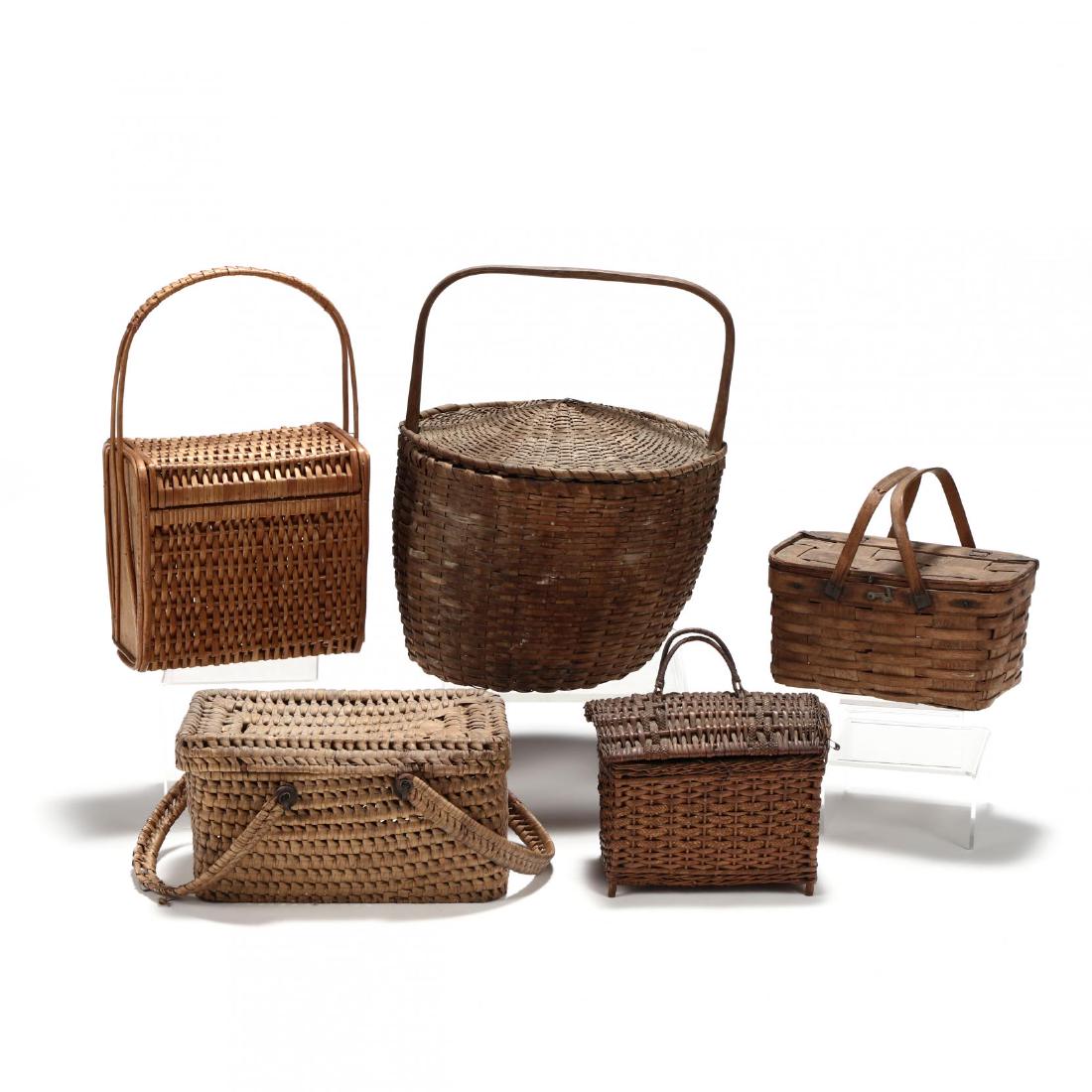 A Group of Five Vintage Lidded Baskets: A Group of Five Vintage Lidded Baskets a wicker sewing basket, retains some sewing accessories; a hinged; lid picnic style basket; an oak splint market basket with sliding cover (several breaks at bot