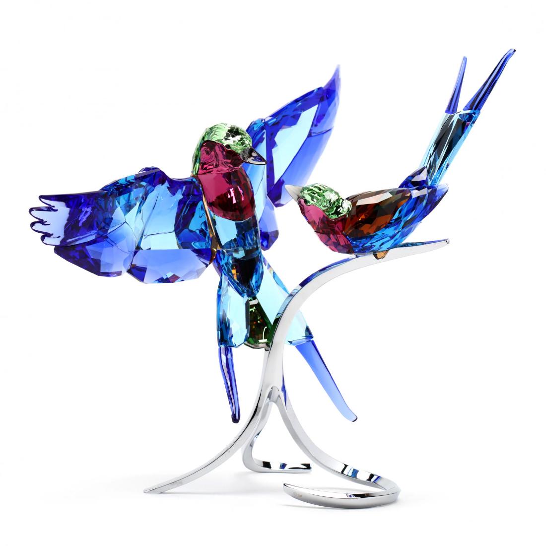 Swarovski, Lilac-Breasted Rollers: Swarovski, Lilac-Breasted Rollers item #5258370, two multi colored faceted birds mounted to a chrome plated stand, marked, with box. 11 x 12 x 8 in. Designed by Juan Ignacio Aliena. Collection of Step
