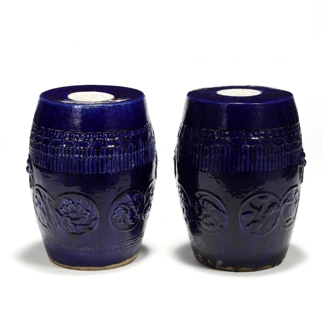 Pair of Chinese Cobalt Glazed Garden Stools: Pair of Chinese Cobalt Glazed Garden Stools 20th century, reticulated top with white glazed detail, body with raised decoration and pierced handles with single character mark painted to underside rim.