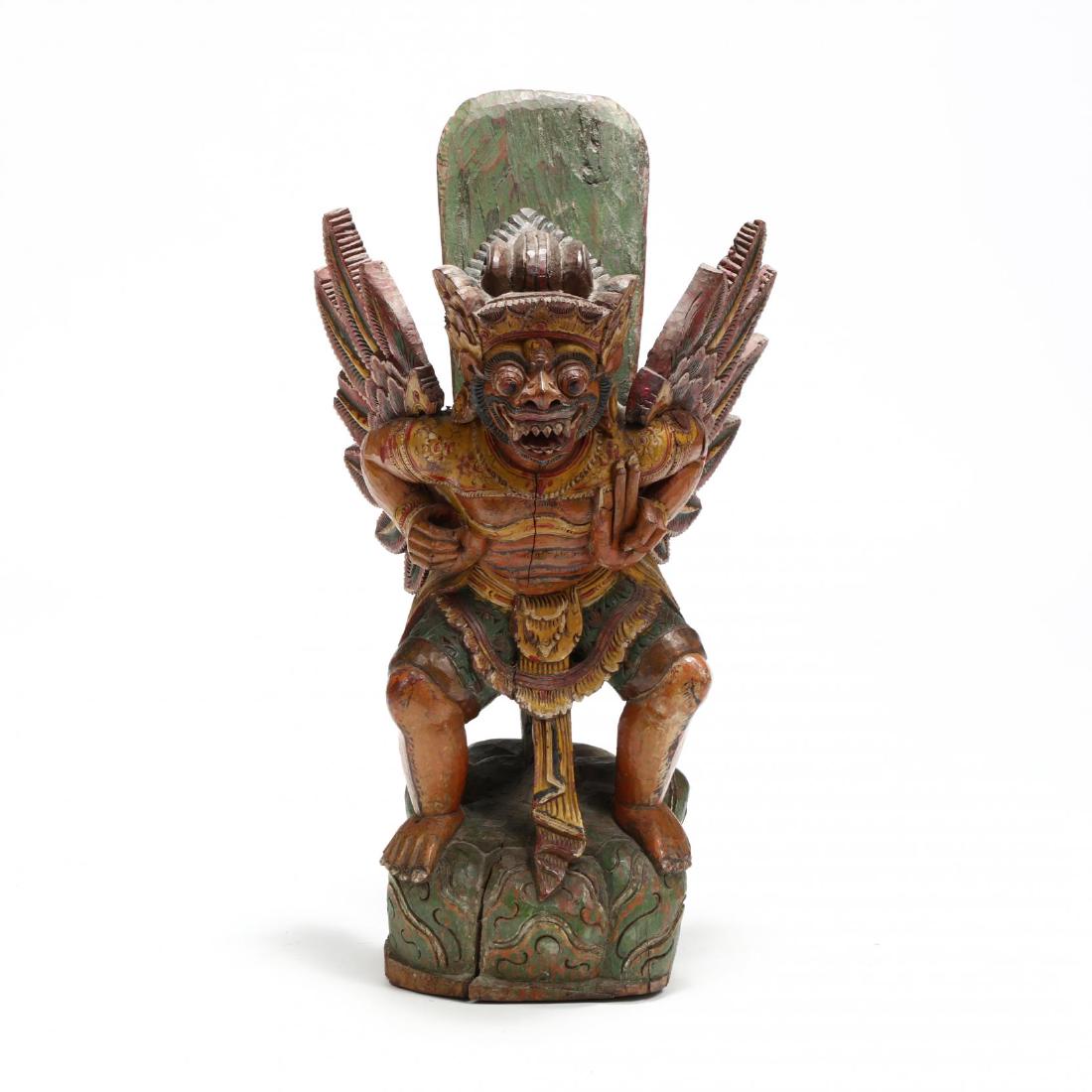 Indonesian Carved and Painted Wood Statue of Garuda: Indonesian Carved and Painted Wood Statue of Garuda late 20th century, solid carved and painted wood, the squatting figure stands atop a swirled green base. 28 x 15 x 15 in. From the Estate of the lat