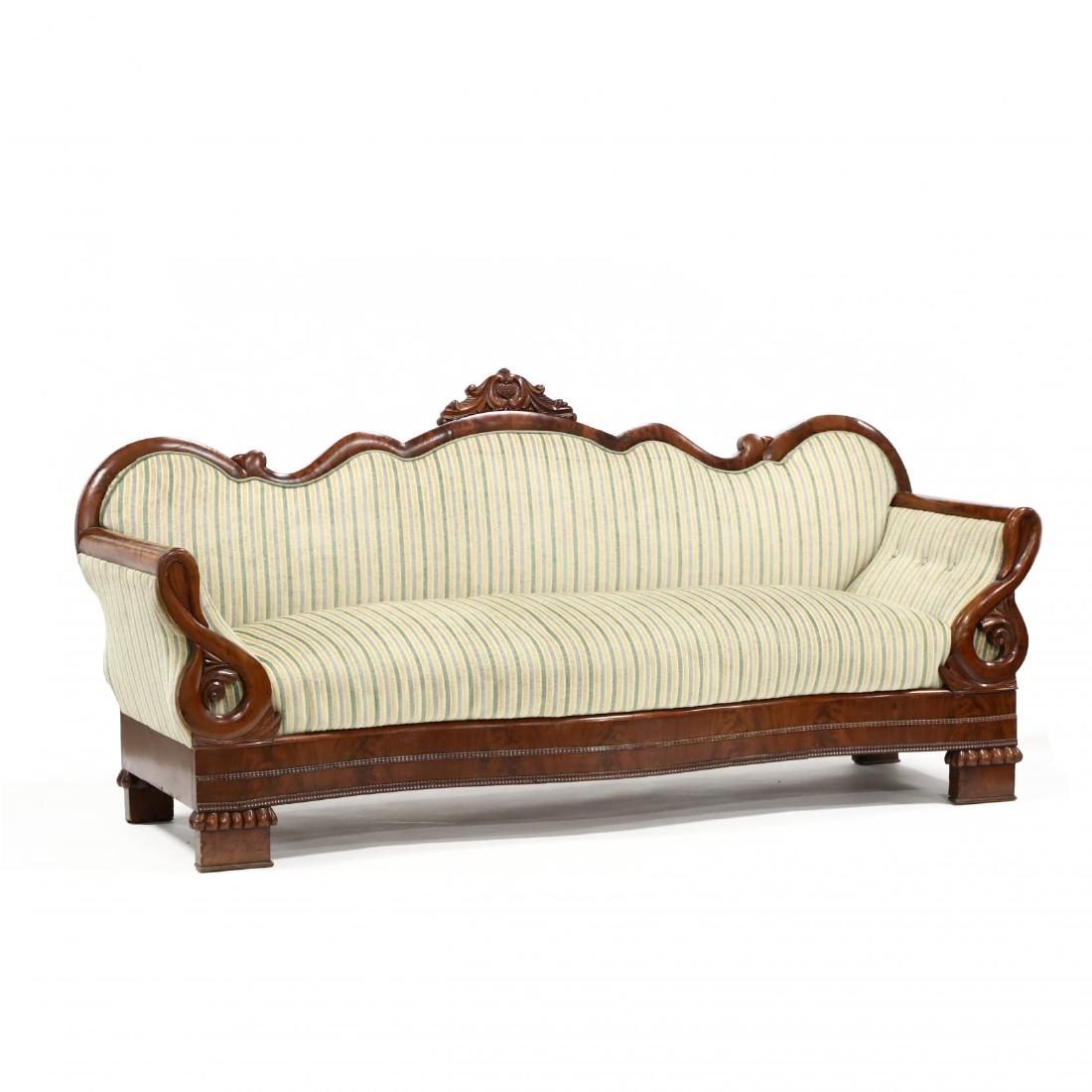 American Classical Mahogany Sofa: American Classical Mahogany Sofa mid 19th century, shaped frame with flame mahogany veneers, heart shaped cut central finial on gooseneck arms with later striped upholstery, serpentine skirt with appl