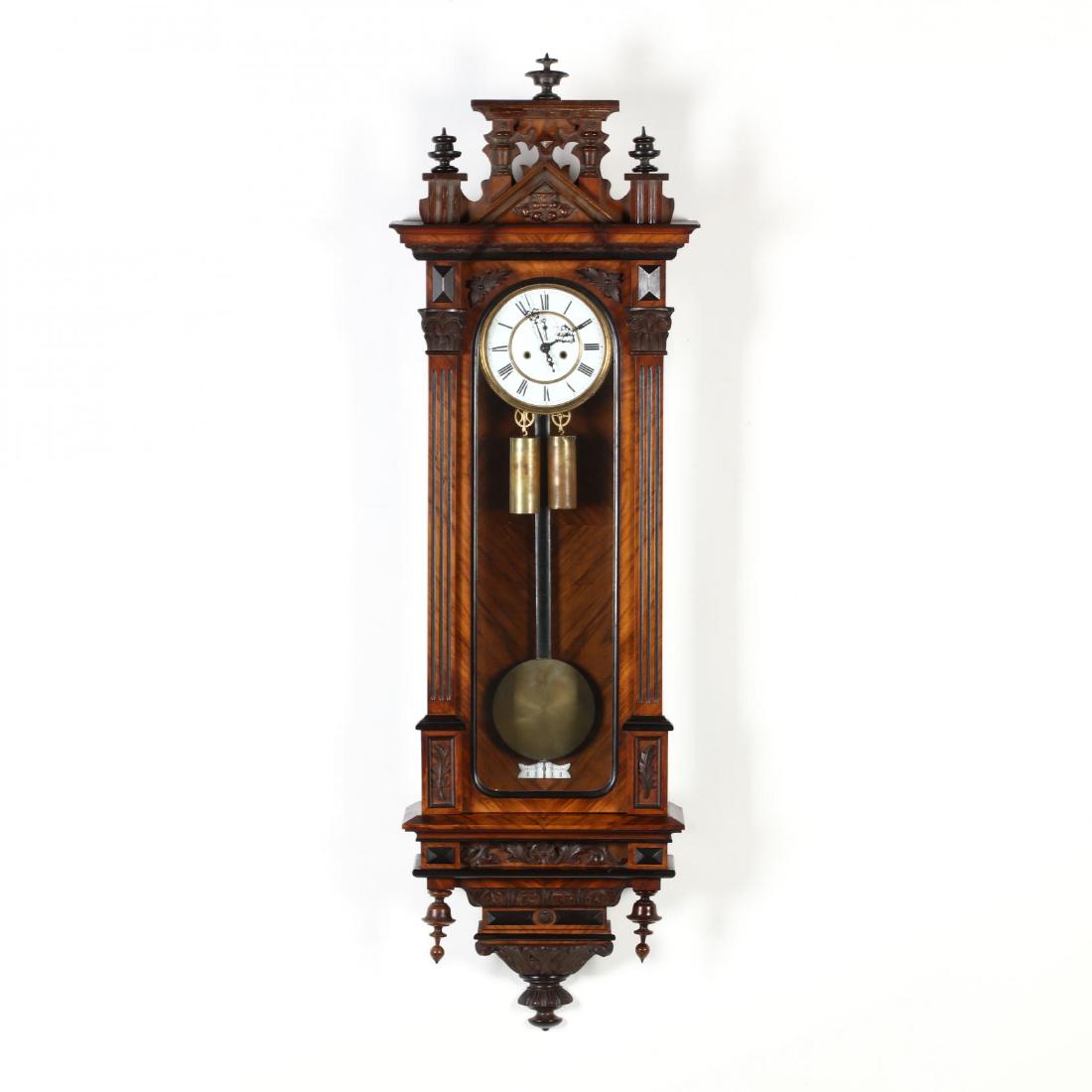 Antique Austrian Wall Clock: Antique Austrian Wall Clock 19th century, enamel face with Roman numerals, walnut case, with ebonized highlights, carved and turned finial pediment, hinged door with fluted columns, over acanthus leaf