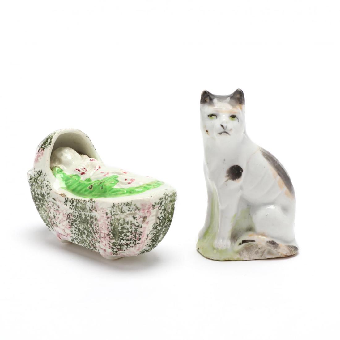 Two Staffordshire Pearlware Pieces: Two Staffordshire Pearlware Piecesearly 19th century, the first is a basketweave-molded hood and bed molded on two rockers, enclosing a small figure of a baby lying asleep, on a green blanket, the cra