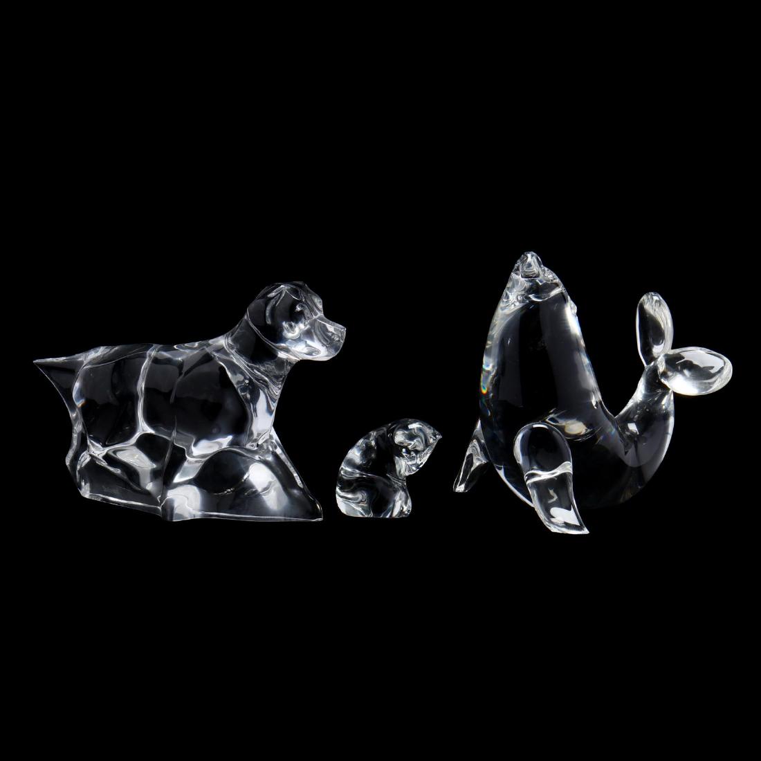 Three Signed Clear Glass Animals: Three Signed Clear Glass Animals a Baccarat seated cat (2 in.); a Steuben sea lion (5 x 4.25 in.); a Baccarat walking dog (5 x 7 in.) Additional high-resolution photos are available at LelandLittle.co