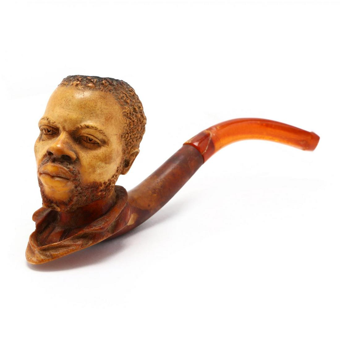 Antique Meerschaum Pipe Featuring African Subject: Antique Meerschaum Pipe Featuring African Subject likely Dutch, late 19th-early 20th century, the bowl carved in the form of a mature black man's bust; included is the pipe's original felt lined case.