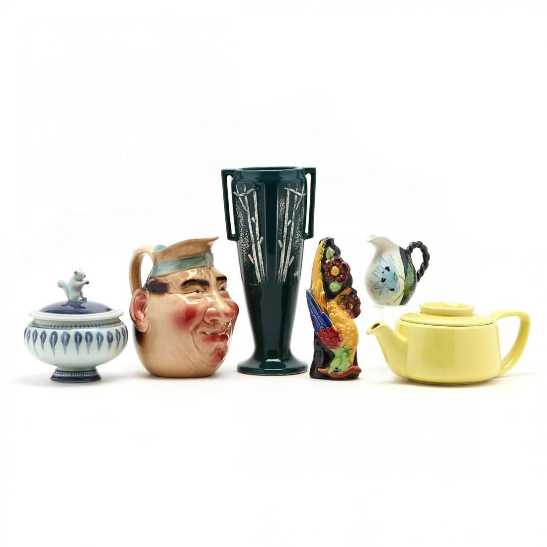 Six Pieces of Utilitarian Art Pottery: Six Pieces of Utilitarian Art Pottery20th century, including a yellow Hall teapot; parrot wall pocket; painted cream pitcher; German face pitcher; M.W. lidded squirrel jar; and a Red Wing double handl